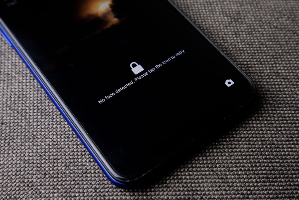 Samsung transforme l’écran de verrouillage des Galaxy en mini-stade pour la Coupe du monde 2026 Mobile phone with no face detected message on lock screen on a textured fabric surface.