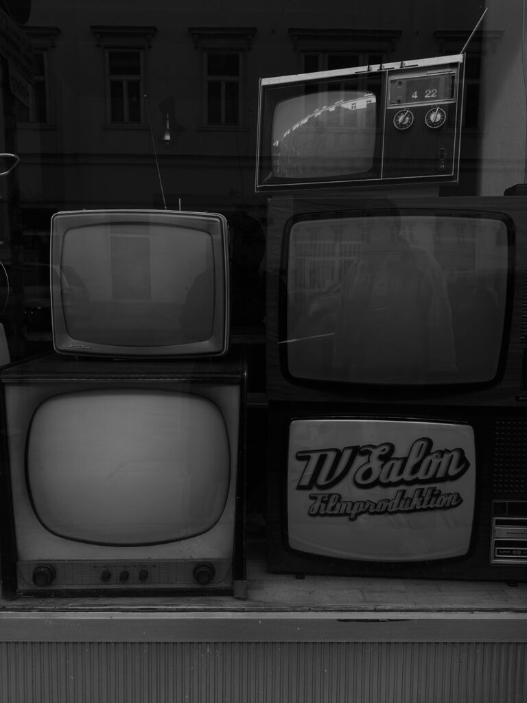 Test du Samsung 65S92H : l’OLED qui fait enfin la paix avec votre salon lumineux Monochrome photo of vintage televisions on display, capturing a sense of nostalgia.