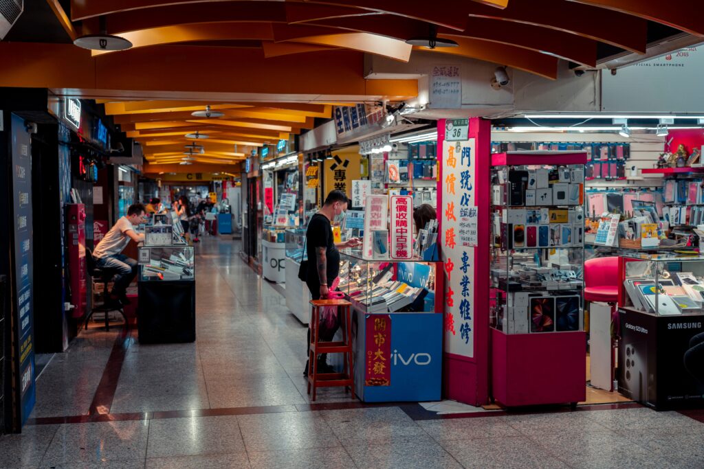 Marché tech France 2026 : les salaires et les métiers qui recrutent Busy indoor electronics market with modern design and engaged shoppers.